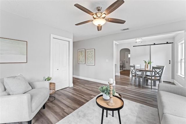 living room featuring ceiling fan and dark wood-type flooring