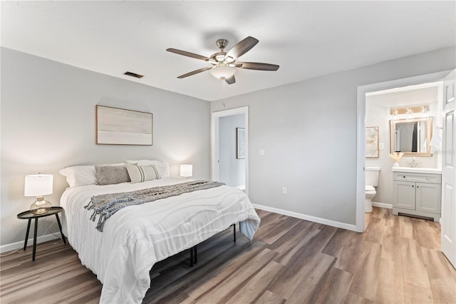 bedroom with hardwood / wood-style flooring, connected bathroom, sink, and ceiling fan