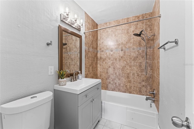 full bathroom featuring tile patterned flooring, tiled shower / bath, vanity, and toilet