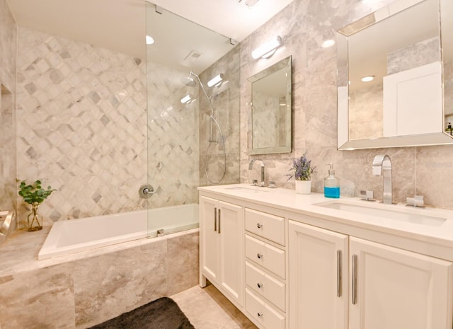 bathroom with vanity, tiled shower / bath combo, and tile walls