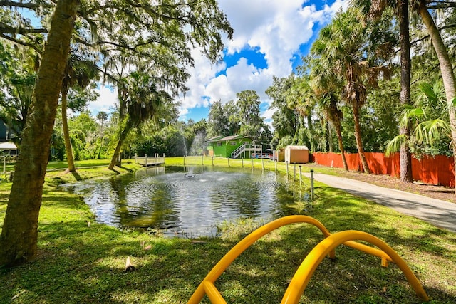 surrounding community featuring a water view and a lawn