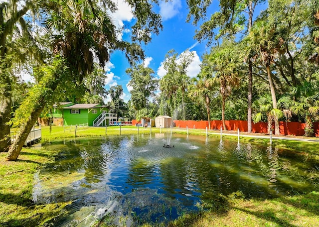 view of community with a water view and a yard