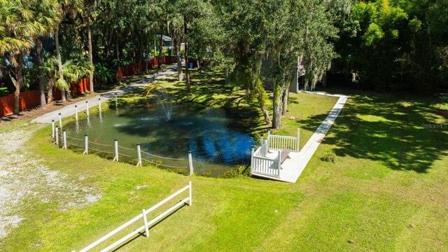 view of property's community with a water view and a lawn