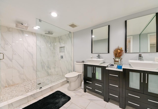 bathroom featuring a shower with shower door, toilet, and vanity