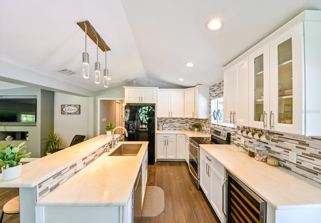 kitchen featuring stainless steel electric range, wine cooler, dark wood-type flooring, lofted ceiling, and a center island with sink