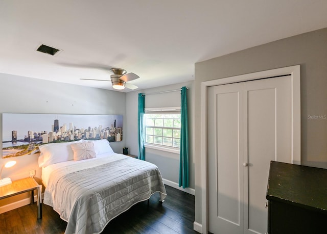 bedroom with dark hardwood / wood-style flooring, ceiling fan, and a closet