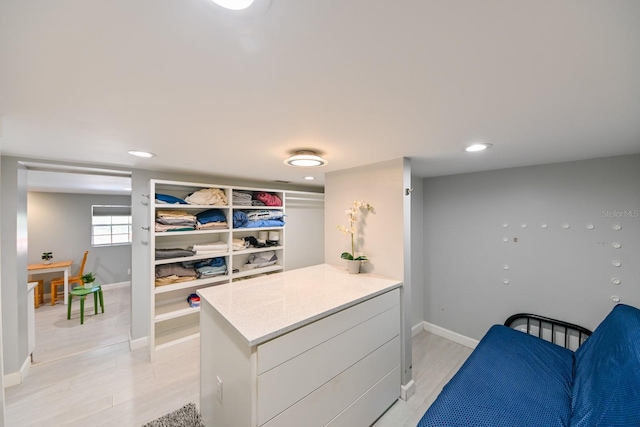 interior space with kitchen peninsula, white cabinetry, and light hardwood / wood-style flooring