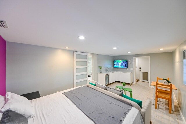 bedroom with light hardwood / wood-style flooring and beverage cooler