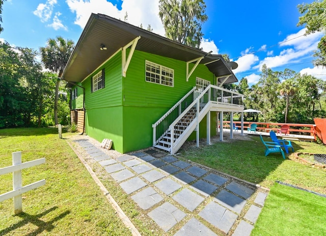 exterior space with a wooden deck, a lawn, and a patio