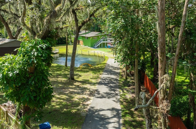 surrounding community featuring a lawn and a water view