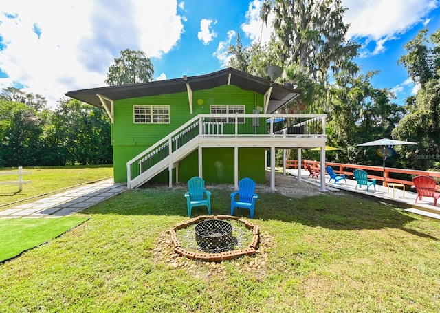 4617 John Moore Rd, Brandon, FL 33511 - back of property with an outdoor fire pit, stairway, a wooden deck, and a yard