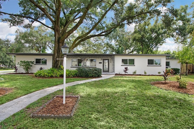 ranch-style house with stucco siding and a front yard