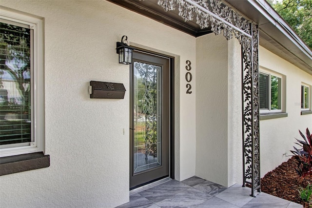 view of exterior entry with stucco siding