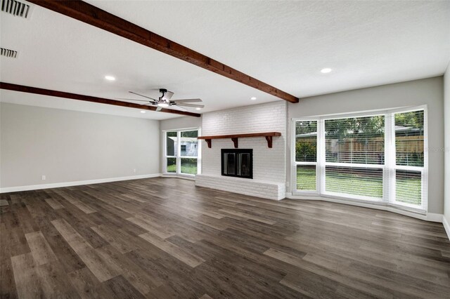 unfurnished living room with a fireplace, beamed ceiling, a textured ceiling, ceiling fan, and dark hardwood / wood-style floors