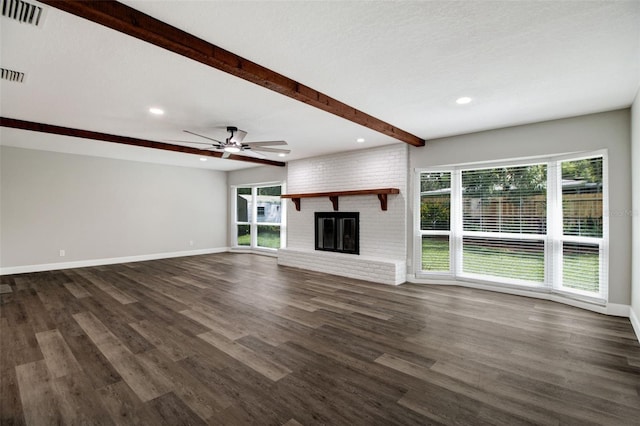 unfurnished living room featuring a brick fireplace, visible vents, beam ceiling, and a healthy amount of sunlight