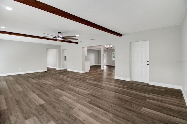 unfurnished living room featuring dark wood-type flooring, ceiling fan with notable chandelier, and beam ceiling