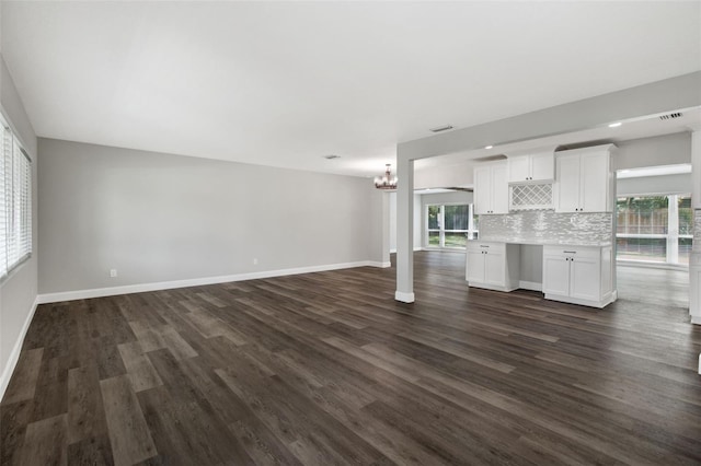 unfurnished living room with a healthy amount of sunlight, dark wood finished floors, and baseboards