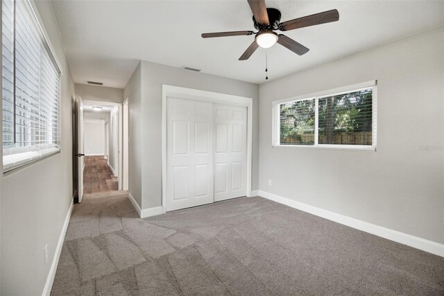 unfurnished bedroom with carpet flooring, ceiling fan, and a closet