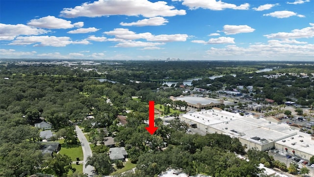 birds eye view of property featuring a water view and a wooded view