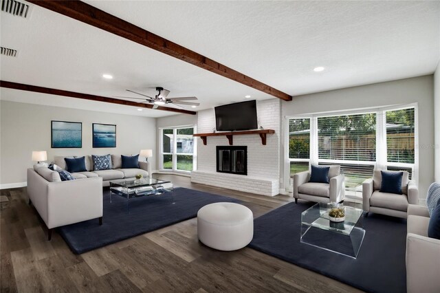 living room with dark hardwood / wood-style flooring, plenty of natural light, a brick fireplace, and ceiling fan