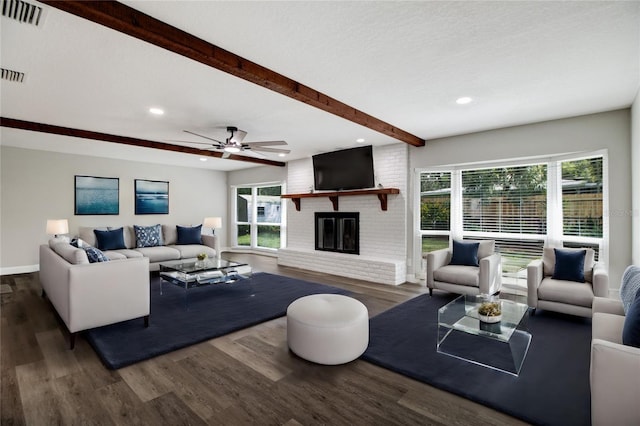 living room with beam ceiling, visible vents, plenty of natural light, and wood finished floors