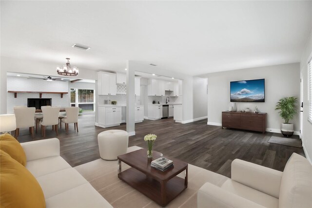 living room featuring dark hardwood / wood-style floors, sink, and a notable chandelier