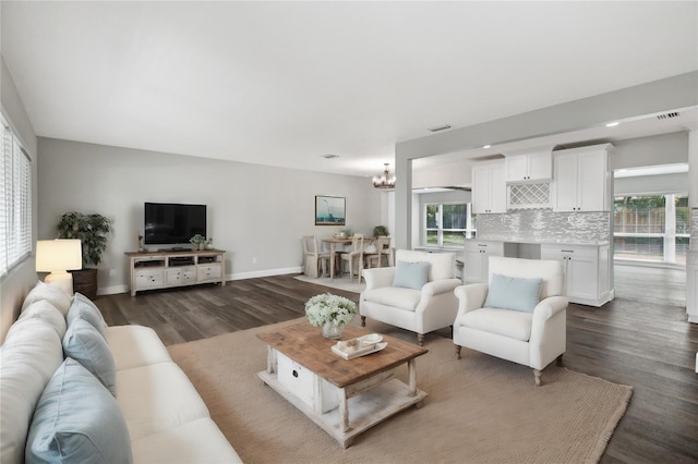 living room with dark wood-type flooring and a chandelier