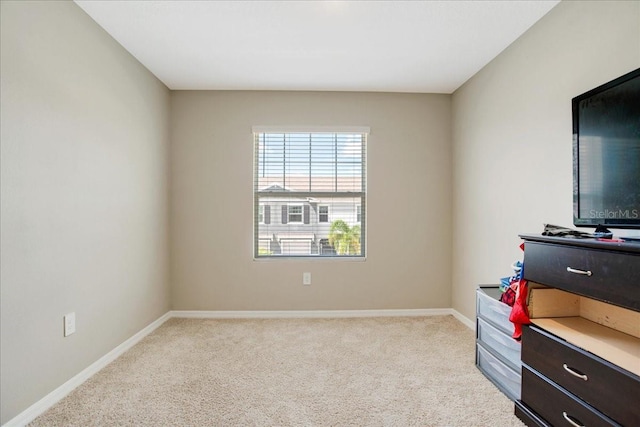 unfurnished room featuring light carpet and baseboards