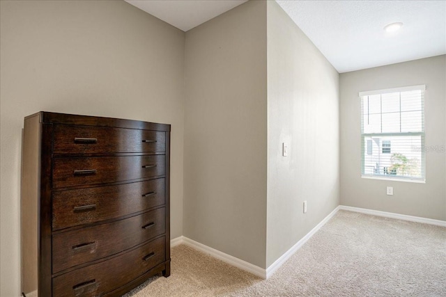 bedroom featuring light colored carpet and baseboards