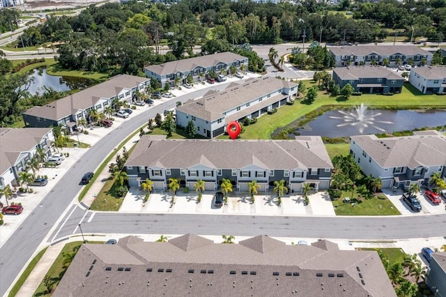 drone / aerial view featuring a residential view and a water view