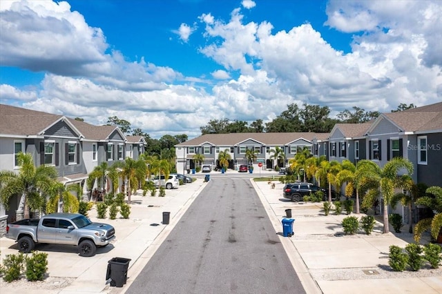 view of street with sidewalks, a residential view, and curbs