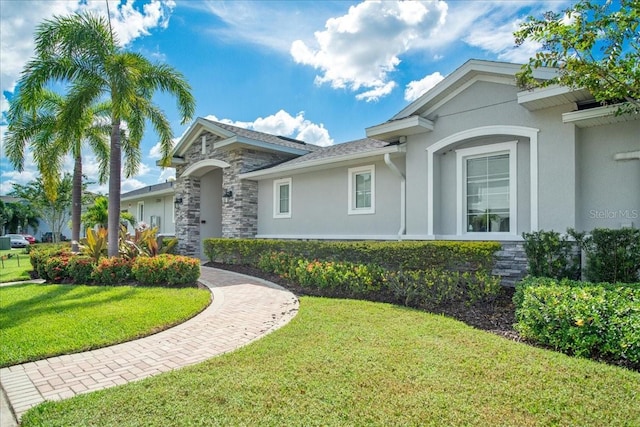 view of front of house with stone siding, a front lawn, and stucco siding