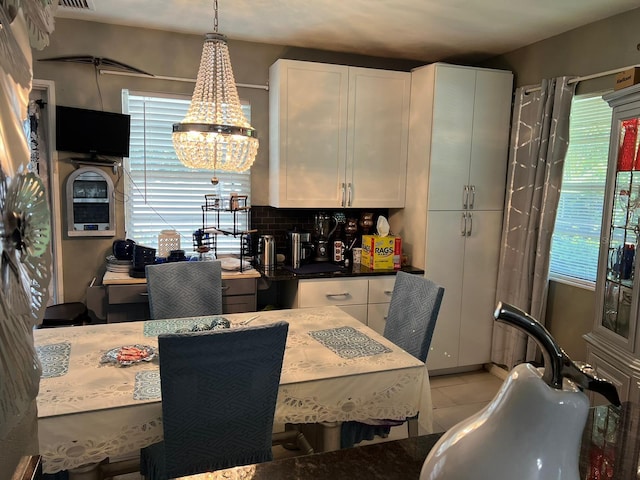 tiled dining area with sink and a chandelier