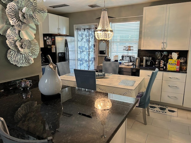 tiled dining area with an inviting chandelier