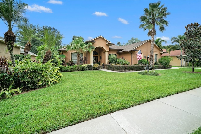 mediterranean / spanish home featuring a front lawn