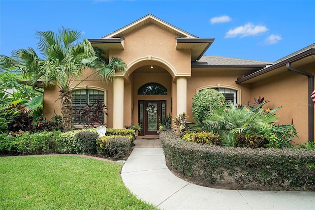 property entrance with a yard and french doors