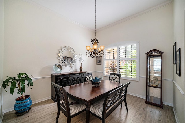 dining space with a chandelier, light hardwood / wood-style floors, and crown molding