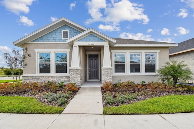 view of front of house featuring stone siding and stucco siding