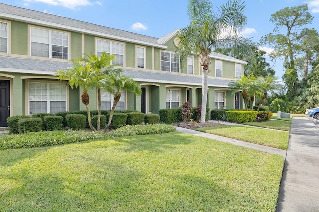 view of property with a front yard and stucco siding