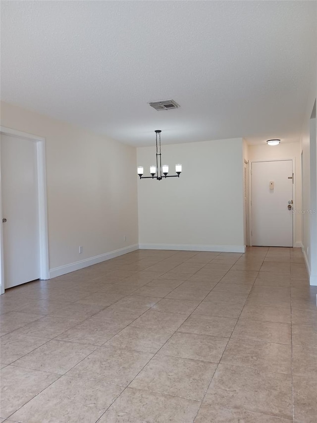4606 W Gray St Unit 110, Tampa, FL 33609 - empty room featuring a chandelier, baseboards, and light tile patterned floors