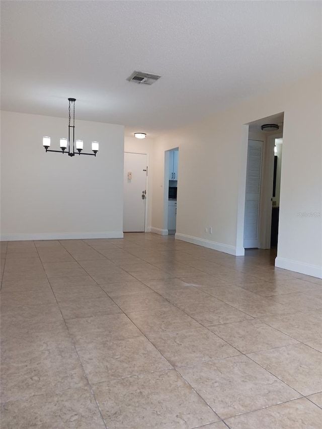 spare room featuring a notable chandelier