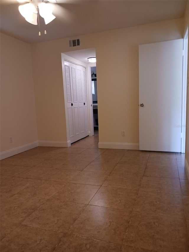 tiled spare room featuring ceiling fan