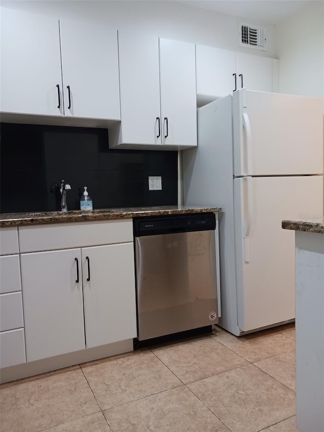 kitchen with light tile patterned floors, dishwasher, white cabinetry, white fridge, and decorative backsplash