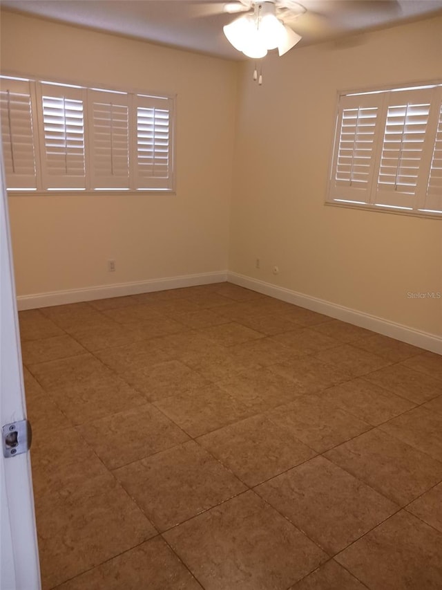 spare room with ceiling fan and tile patterned floors