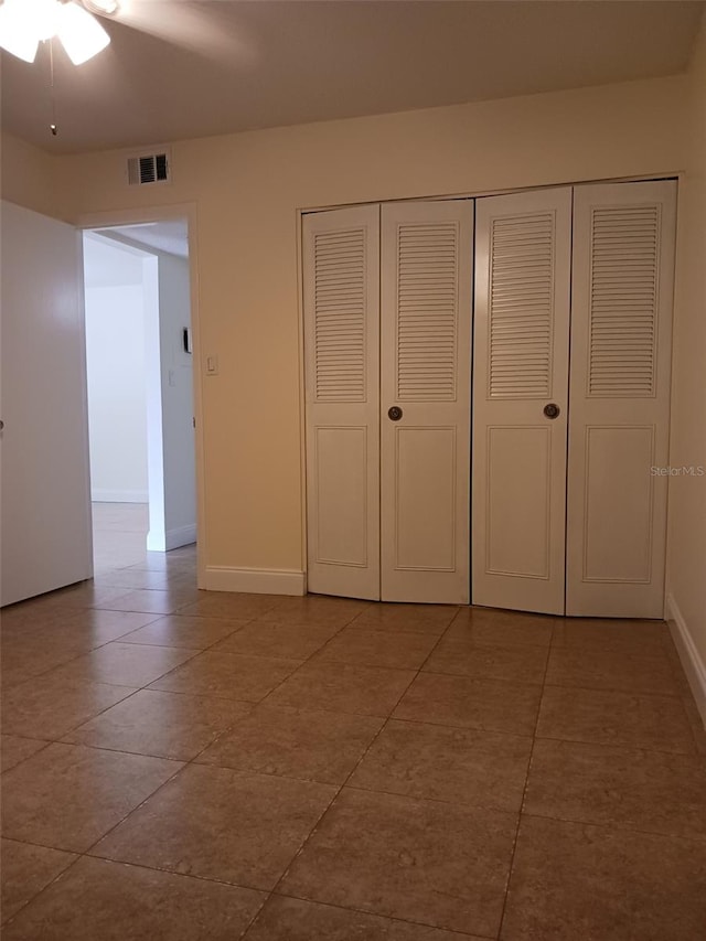 unfurnished bedroom with ceiling fan and light tile patterned floors