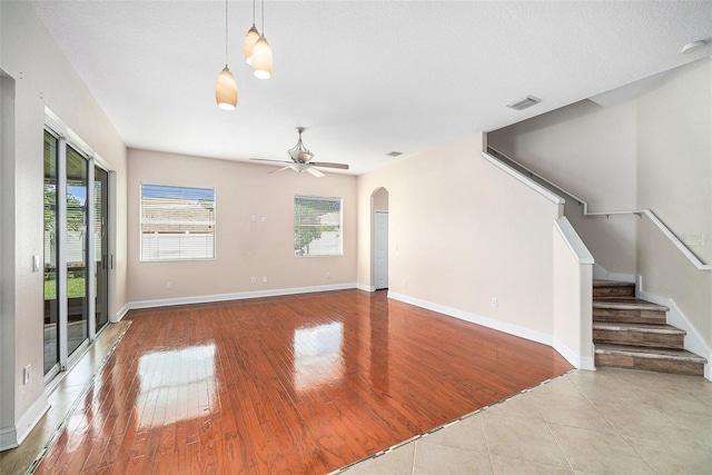 unfurnished living room featuring a textured ceiling, light hardwood / wood-style flooring, and ceiling fan