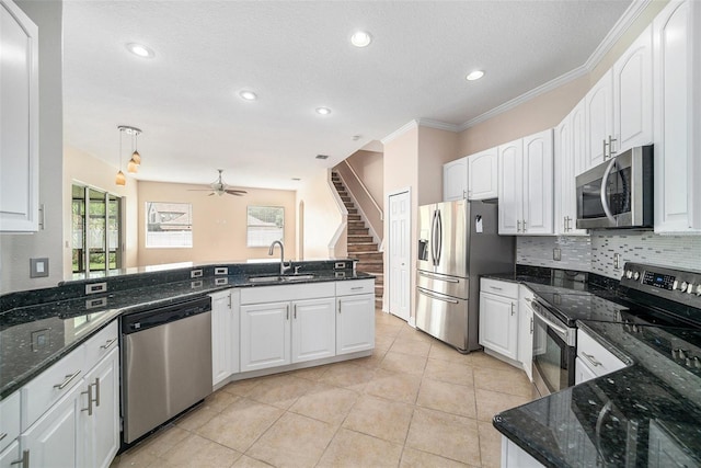 kitchen featuring hanging light fixtures, stainless steel appliances, ornamental molding, sink, and ceiling fan