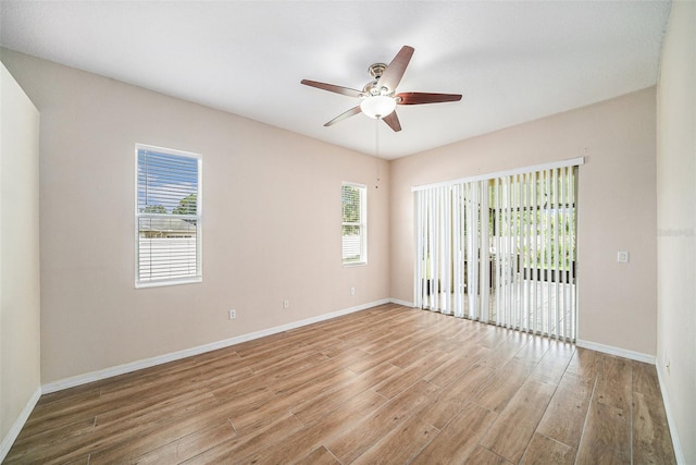 spare room featuring plenty of natural light, wood-type flooring, and ceiling fan