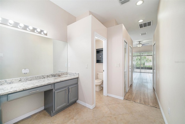 bathroom with vanity, toilet, tile patterned floors, and ceiling fan