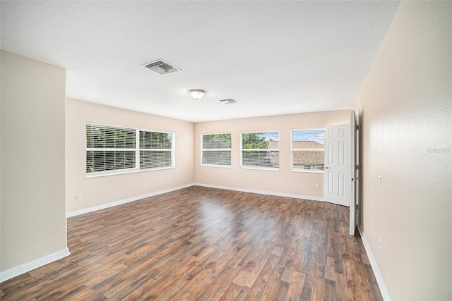 interior space featuring a textured ceiling and dark hardwood / wood-style floors